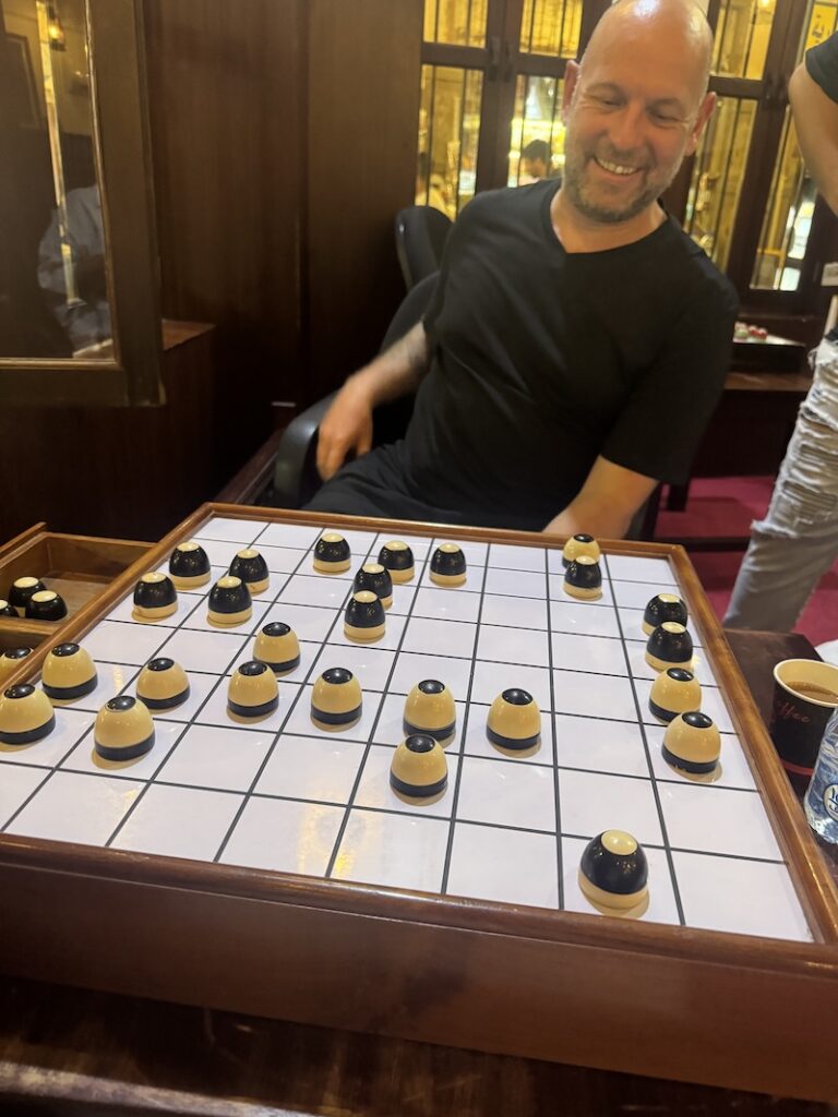 Playing a traditional game of Dama with a local man in Souq Waqif