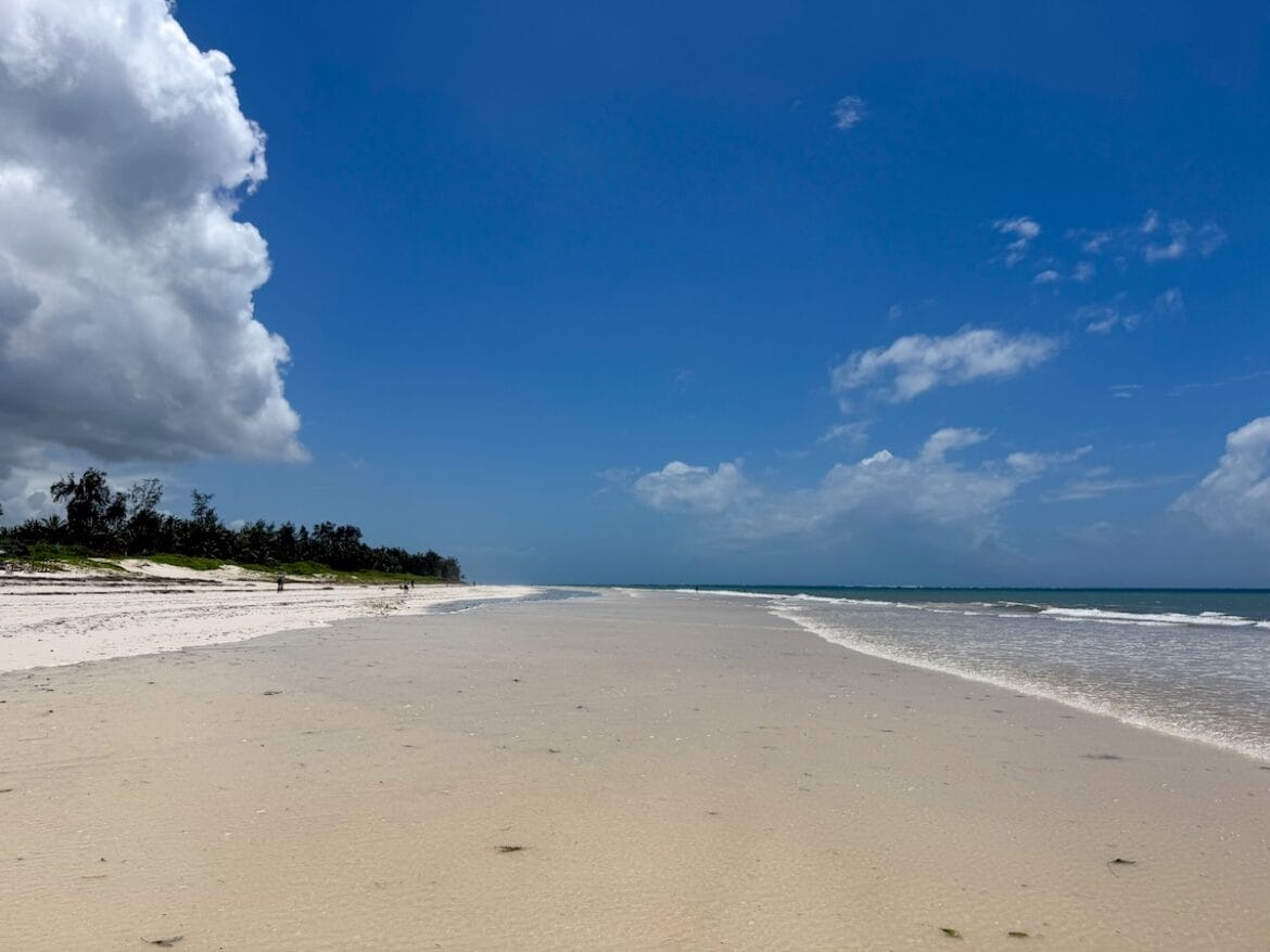 Long, almost empty stretch of Bofa Beach in Kilifi, Kenya, at low tide