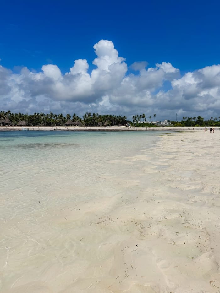 Walking across the exposed shoreline at low tide in Diani